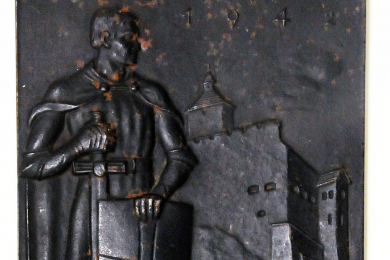 Kleines rechteckiges Relief aus Eisenguss, im Vordergrund ein Ritter mit Schild und Schwert, im Hintergrund eine Burg an einem Fluss, oben die Jahreszahl 1942.