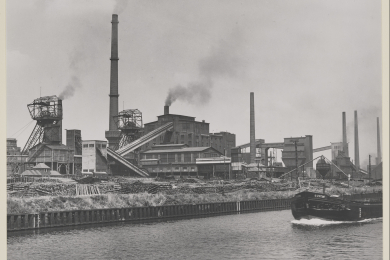 Die Anlage der Zeche Emscher-Lippe um 1958 mit den Fördergerüsten des Bergwerks und Kohlentürmen der Kokerei. Im Vordergrund ist der Dortmund-Ems-Kanal mit einem Schiff zu erkennen.