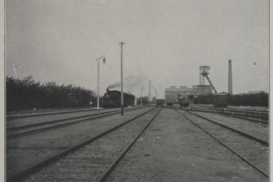 Blick über Bahngleise auf die Tagesanlagen des Bergwerks 
