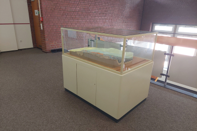 Unterschrank mit einem Blockmodell und einer Glashaube in einem Flur der Technischen Hochschule Georg Agricola.