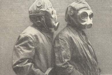 Das Bild zeigt das Halbporträt zweier Männer, die jeweils eine Flammenschutzkleidung tragen und deren Gesicht mit einer Flammenschutzhaube abgedeckt ist