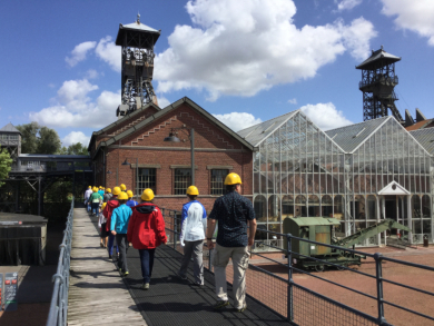 Besucher nähern sich über eine Brücke der Zechenanlage