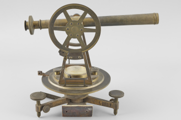 Messing Instrument bestehend aus einem Fernrohr auf zwei Trägern mit großem Gradkreis, darunter eine runde Platte mit Libelle in der Mitte, unten ein Dreifuß.