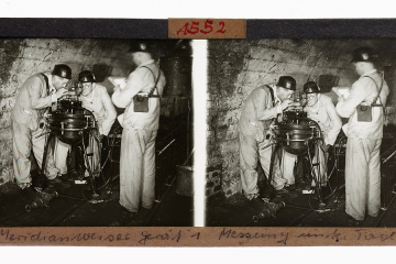 Das Bild zeigt drei Bergleute bei der Messung mit dem Meridianweiser MW 1 unter Tage, ca. 1950
