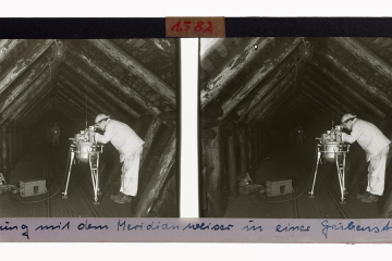 Das Bild zeigt einen Bergmann bei der Messung mit dem Meridianweiser MW 4a unter Tage, ca. 1960. Der Markscheider schaut durch ein Spektiv, links am Boden stehen die Batterie und ein Werkzeugkoffer.