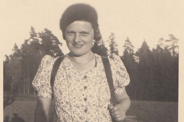 Sepia-Fotografie einer lächelnden Frau beim Wandern.