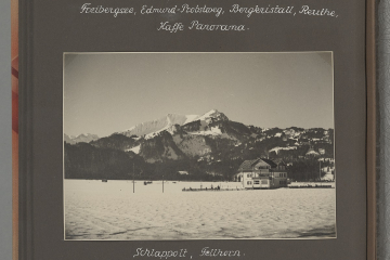 Fotografie einer Landschaft mit einem Gebäude und im Hintergrund Berge im Winter in einem Fotoalbum eingeklebt mit Beschriftung