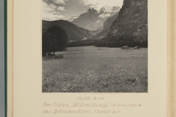 Fotografie einer Berglandschaft im Vordergrund Wiese und im Hintergrund Berge im Sommer in einem Fotoalbum eingeklebt mit Beschriftung