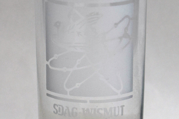 Bierglas mit Gravur eines stilisierten Atoms drei Umlaufbahnen und eine Taube sowie Schriftzug 