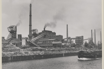 Die Anlage der Zeche Emscher-Lippe um 1958 mit den Fördergerüsten des Bergwerks und Kohlentürmen der Kokerei. Im Vordergrund ist der Dortmund-Ems-Kanal mit einem Schiff zu erkennen.