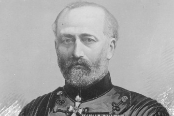 Das Bild zeigt das Halbporträt eines Mannes mit Vollbart, der eine mit Orden und Auszeichnungen bestückte schwarze Uniformjacke trägt
