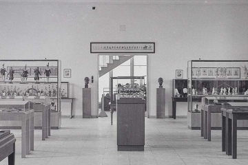 Ausschnitt aus einem schwarz-weiß-Foto einer Ausstellungshalle, in deren Zentrum die Bergparade unter einer Glashaube steht.