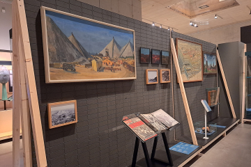 Blick in einen Ausstellungsraum mit Objekten und Gemälden.