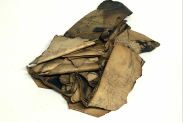 in einem Haufen zusammengepappte Buchseiten mit Brandspuren