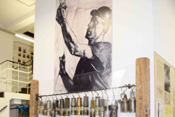 Ein Ausstellungsraum mit aneinander gereihten Grubenlampen.
