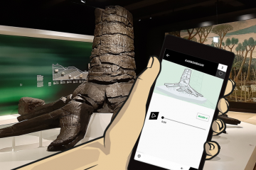 Eine Hand hält den Bildschirm eines Smartphones vor einen fossilen Baum