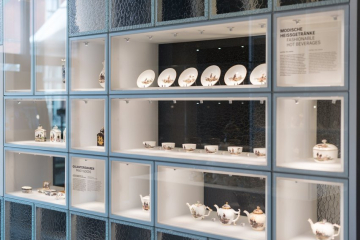 Eine Vitrine mit Teilen eines bemalten Porzellangeschirrs