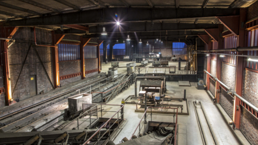 Eine Halle mit Grubenwagen und Gleisen